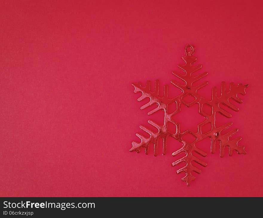 Ornament red snowflake on red background with copy space