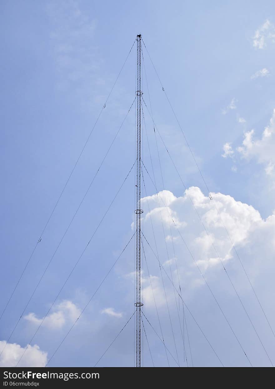 High communication pole on cloudy sky and sunlight