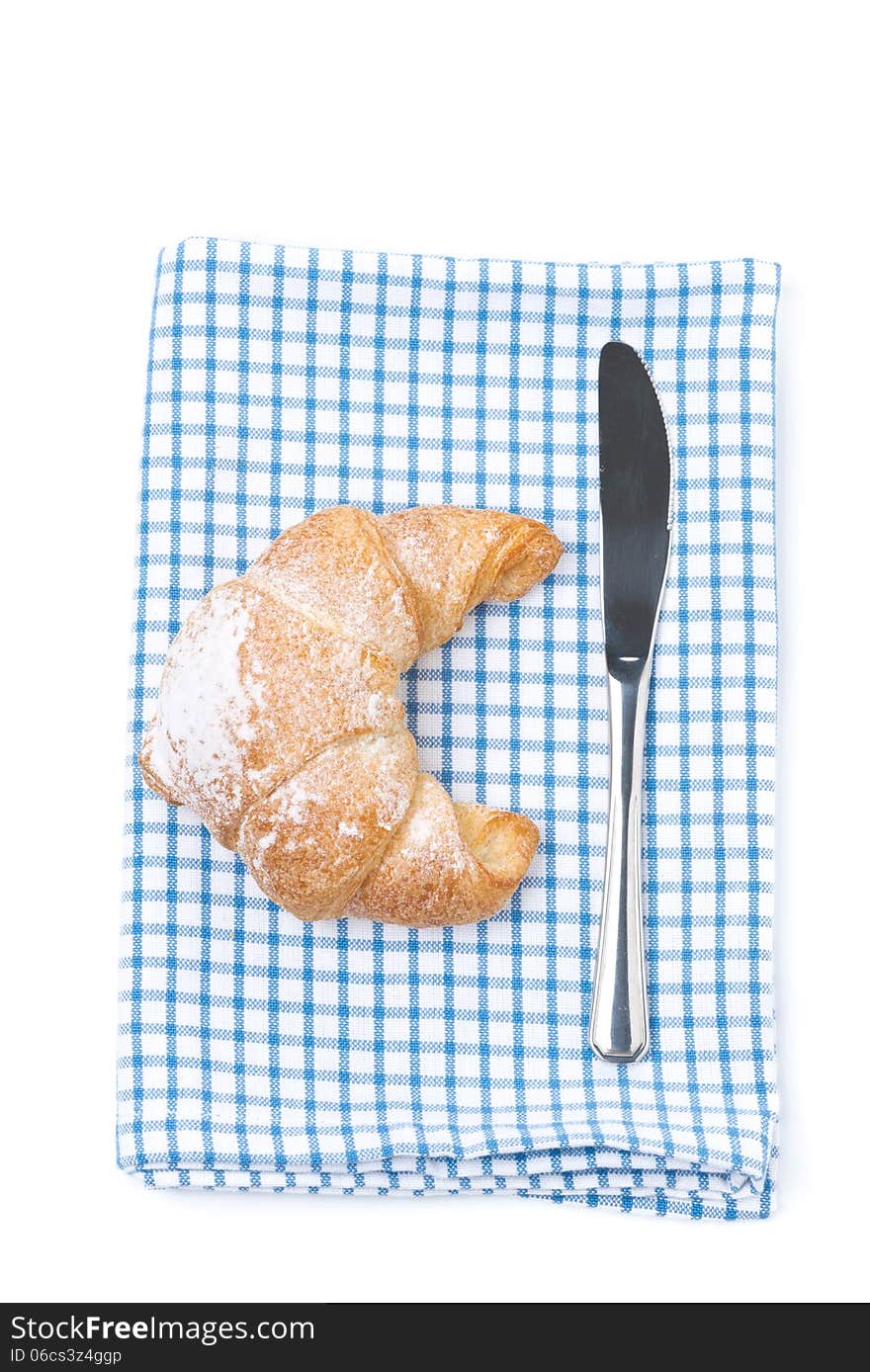 Croissant and a knife on a napkin, isolated