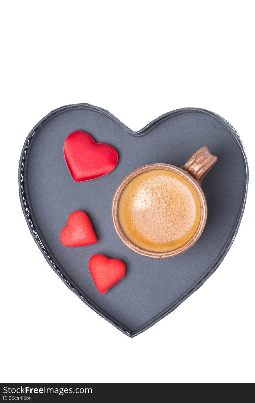 Cup of coffee and candy on a tray in the form of heart, isolated