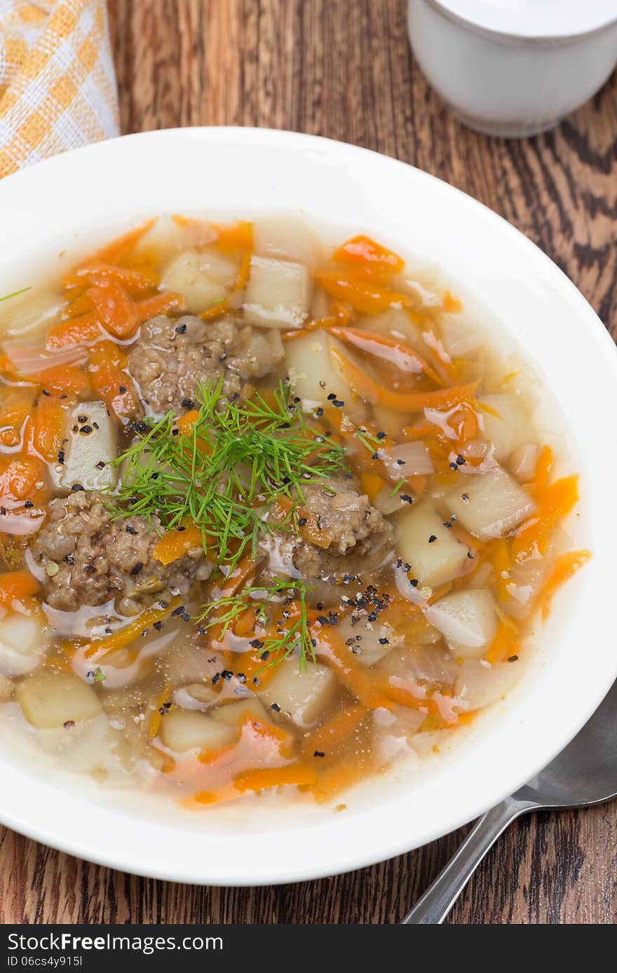 Delicious vegetable soup with meatballs, vertical, close-up