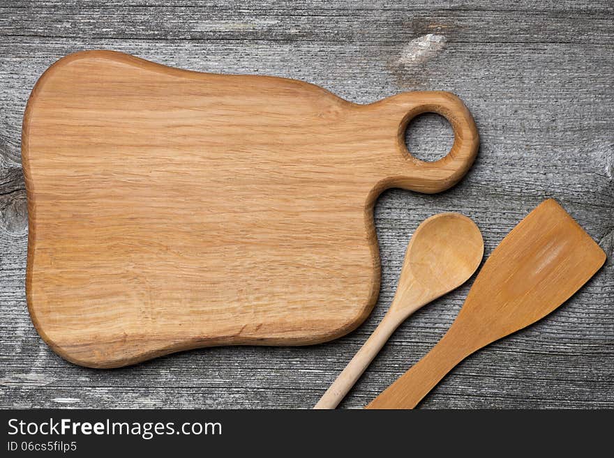 Figured wooden cutting board, spoon and spatula, concept, place for the recipe, top view