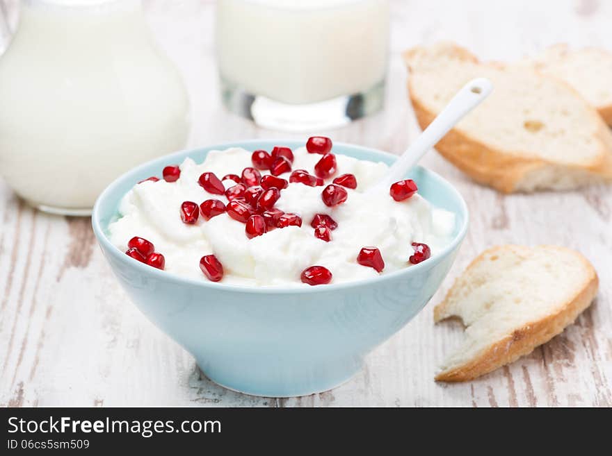 Homemade yogurt with pomegranate, milk and bread, close-up, horizontal