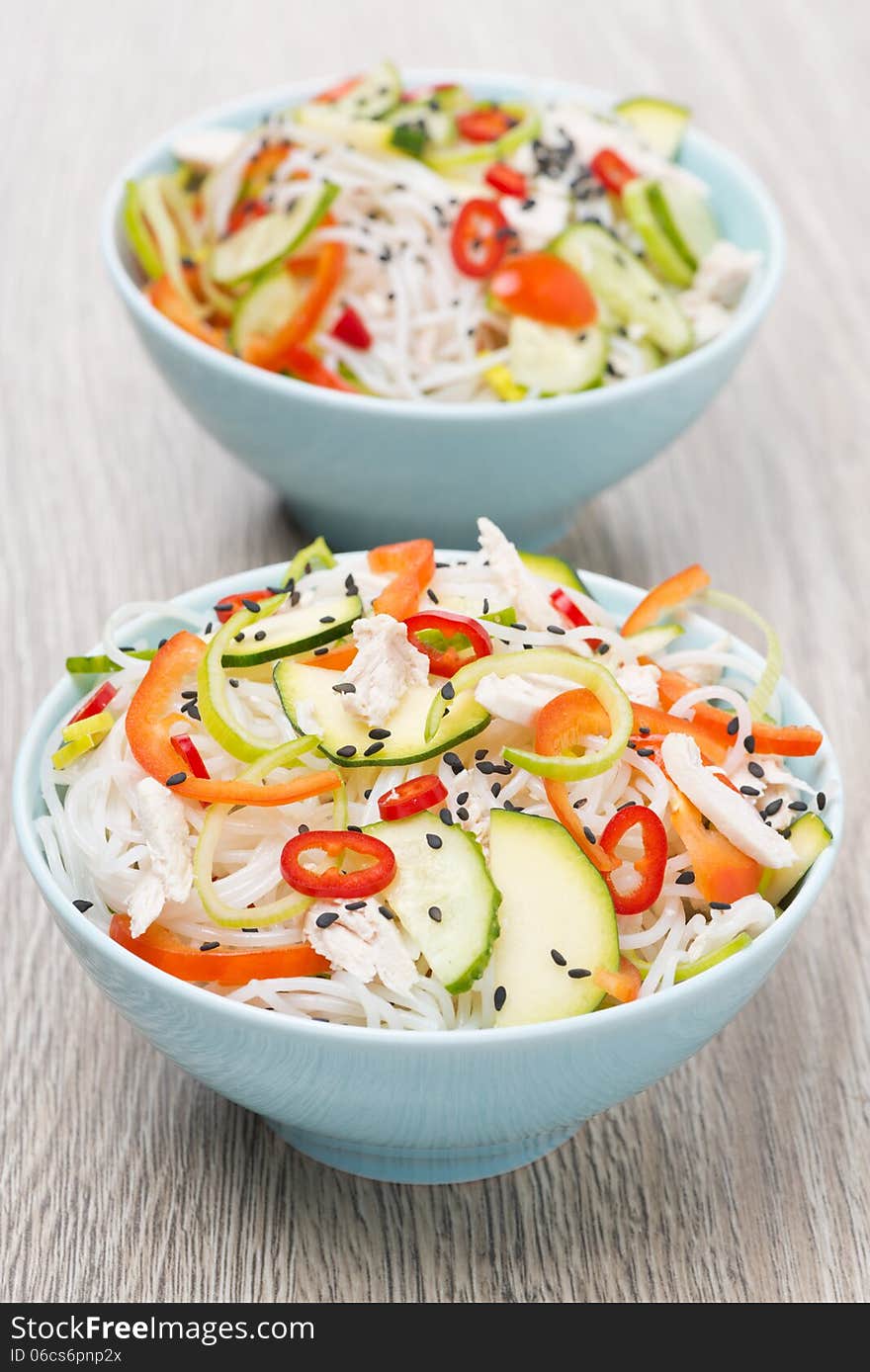 Two bowls of Thai salad with vegetables, rice noodle and chicken