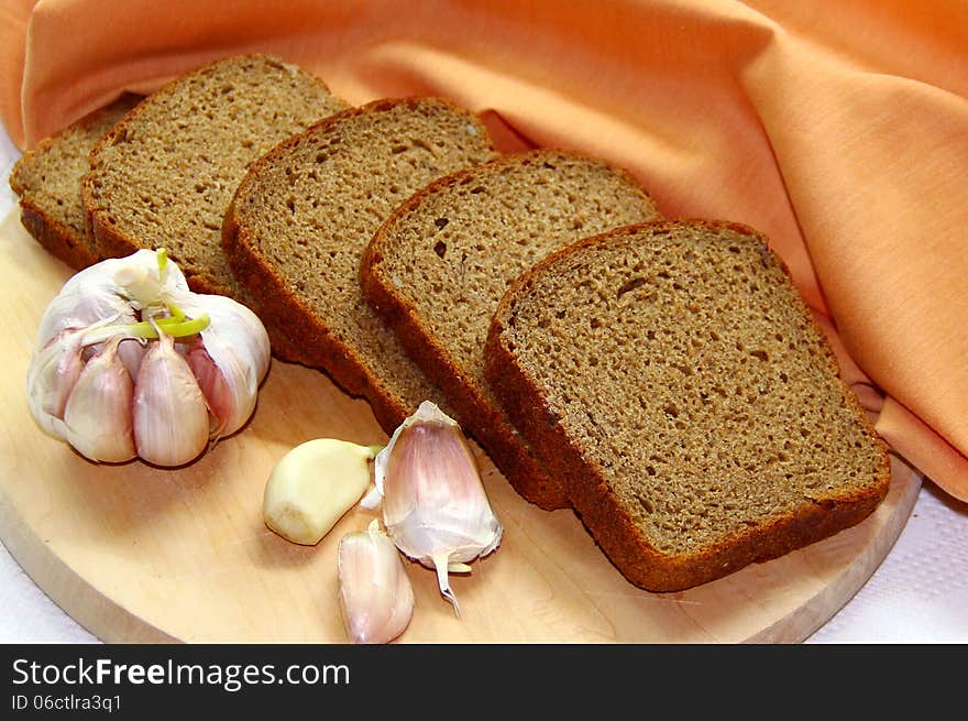 Rye-bread and garlic on the wooden table