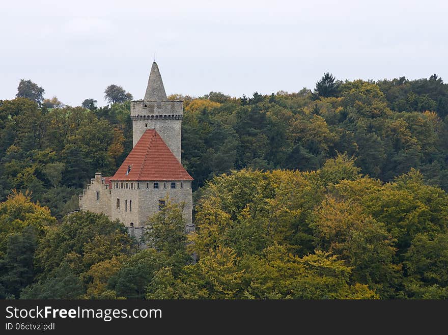 Castle with red roof in the middle of autumn forest. Castle with red roof in the middle of autumn forest