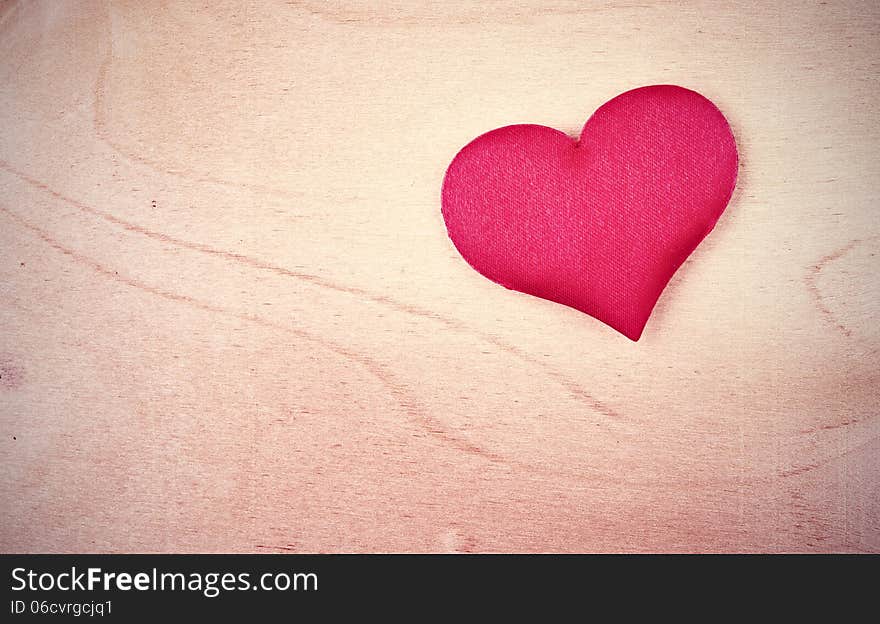 Valentine card. red heart on a light wooden background