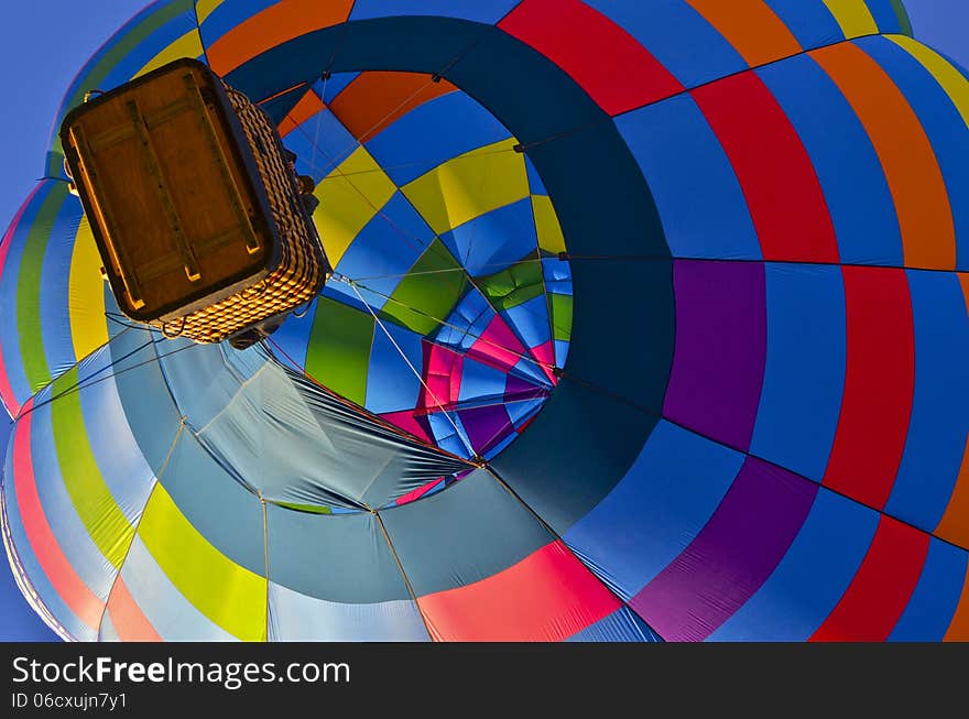 Multi-colored hot air balloon fills the morning sky over Arizona.