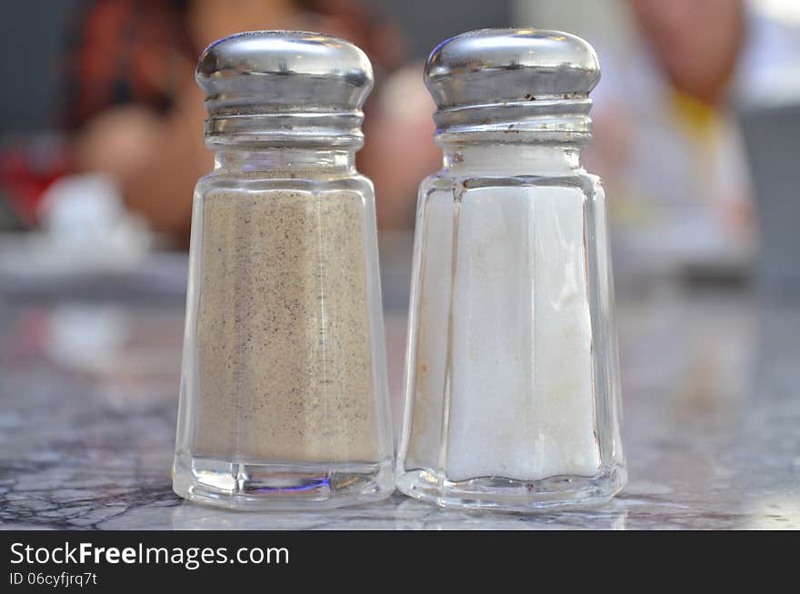 Glass salt and pepper shakers on table