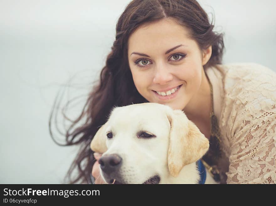 Portrait of beautiful young woman playing with dog on the sea shore. Portrait of beautiful young woman playing with dog on the sea shore