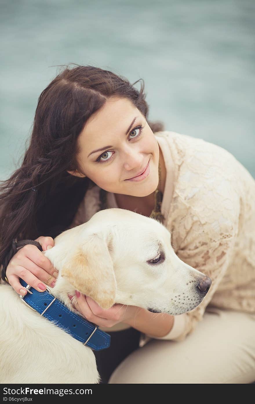 Portrait of beautiful young woman playing with dog on the sea shore. Portrait of beautiful young woman playing with dog on the sea shore