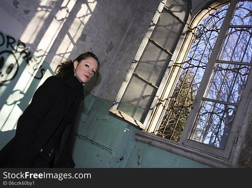 Model posing in long coat in abandoned place. Model posing in long coat in abandoned place