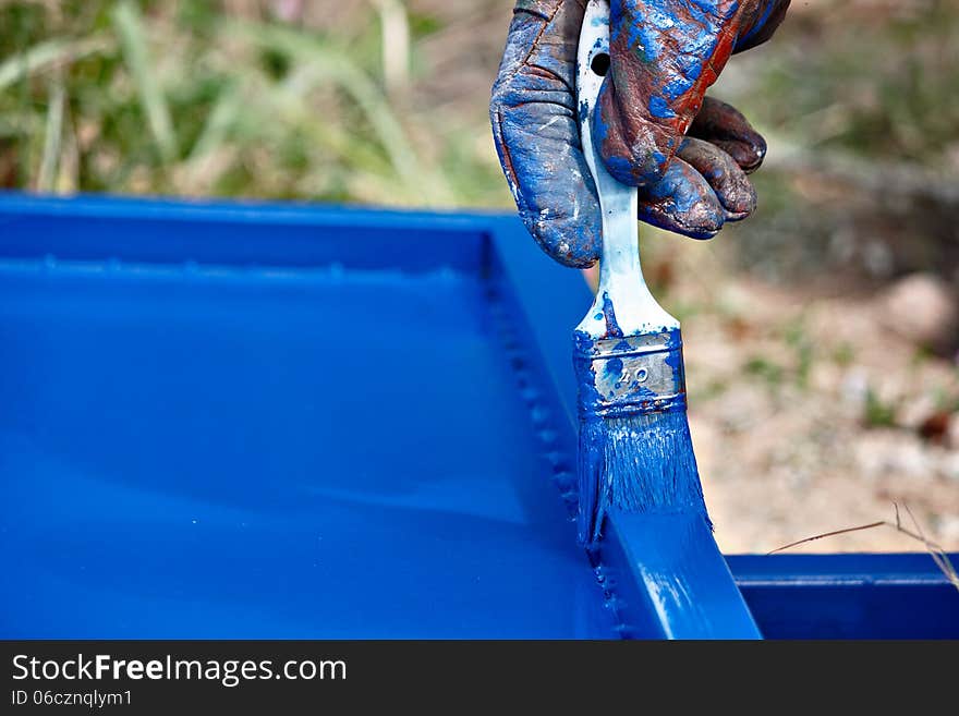 Painting metal profiles in blue with a brush