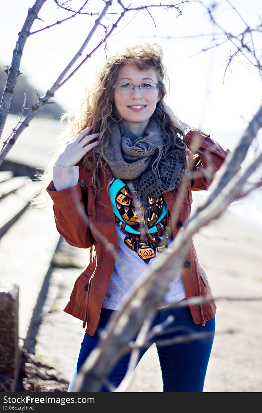 Happy Woman With Glasses And Curly Hair On Bright Sunny Background