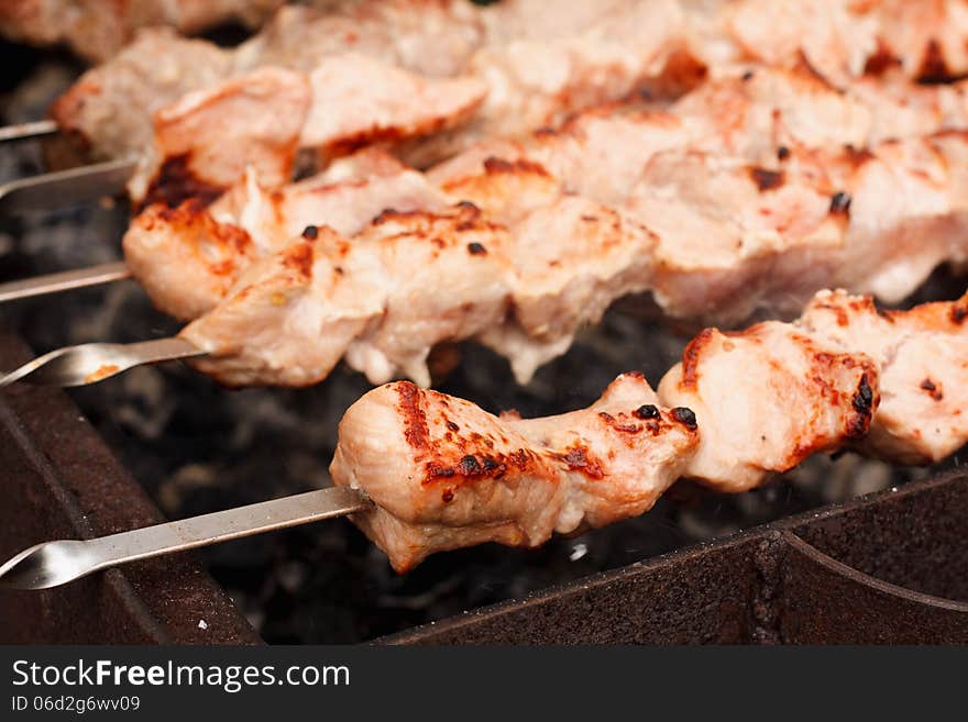 Shish kebab in process of cooking on open fire outdoors / Juicy slices of meat with sauce prepare on fire (shish kebab). Shish kebab in process of cooking on open fire outdoors / Juicy slices of meat with sauce prepare on fire (shish kebab)