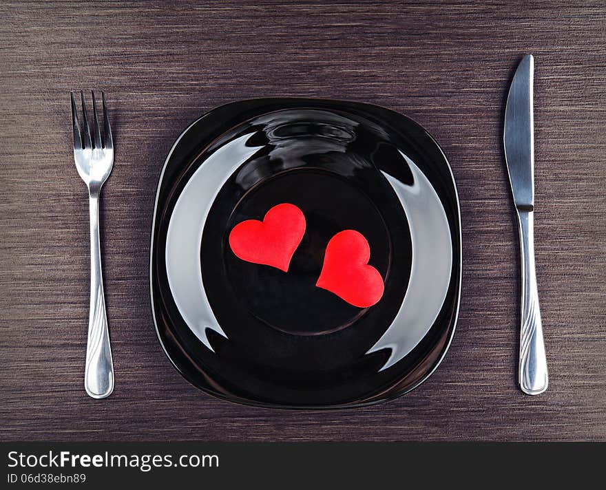 Table setting for Valentine's Day. plate, fork, knife and red heart