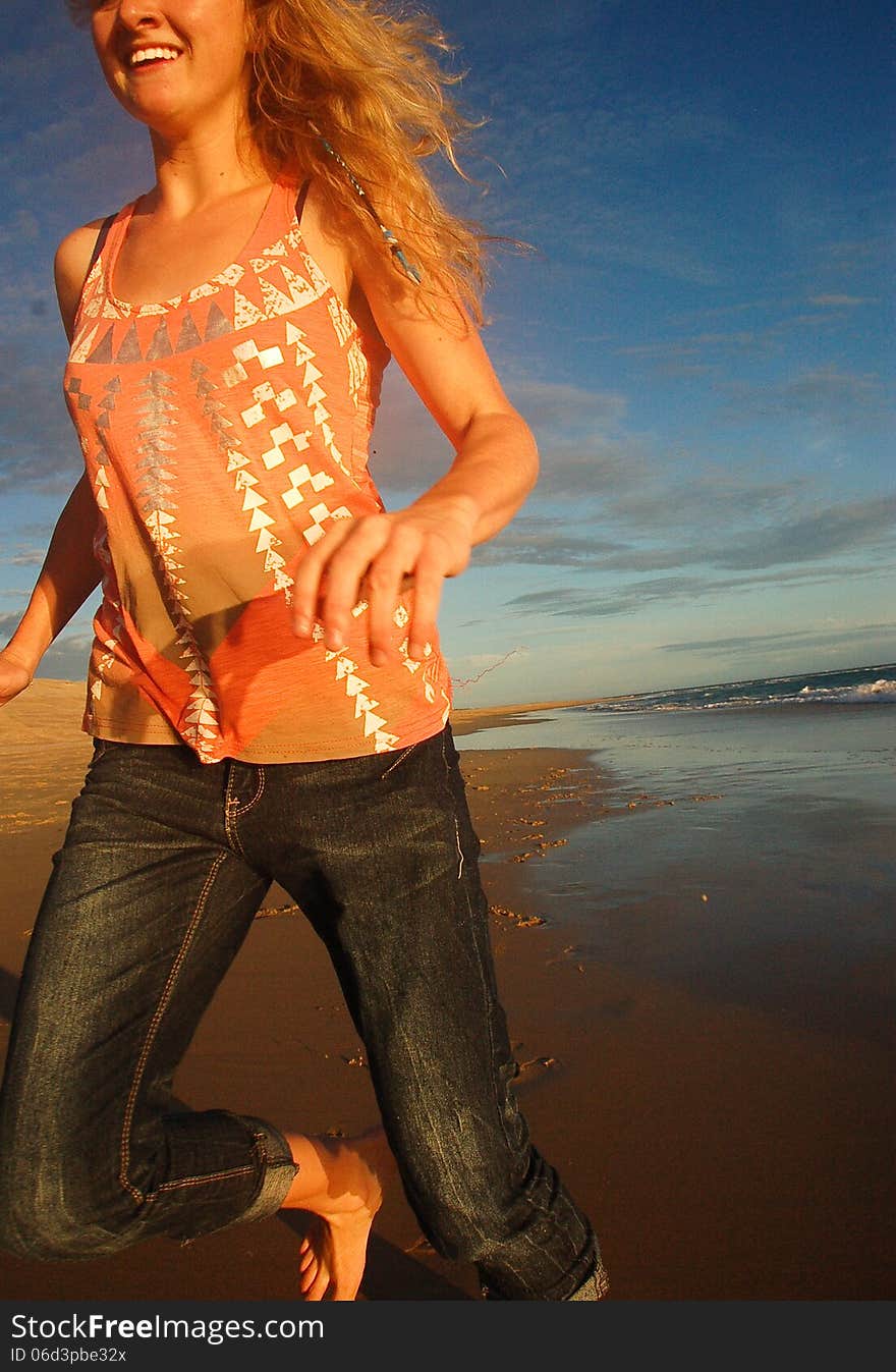 A close up of a smiling young girl running past barefoot on the beach. A close up of a smiling young girl running past barefoot on the beach.