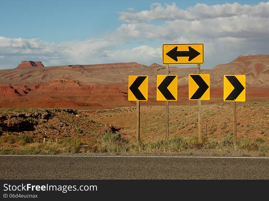 Bright yellow directional traffic arrow signs along desert highway. Bright yellow directional traffic arrow signs along desert highway.