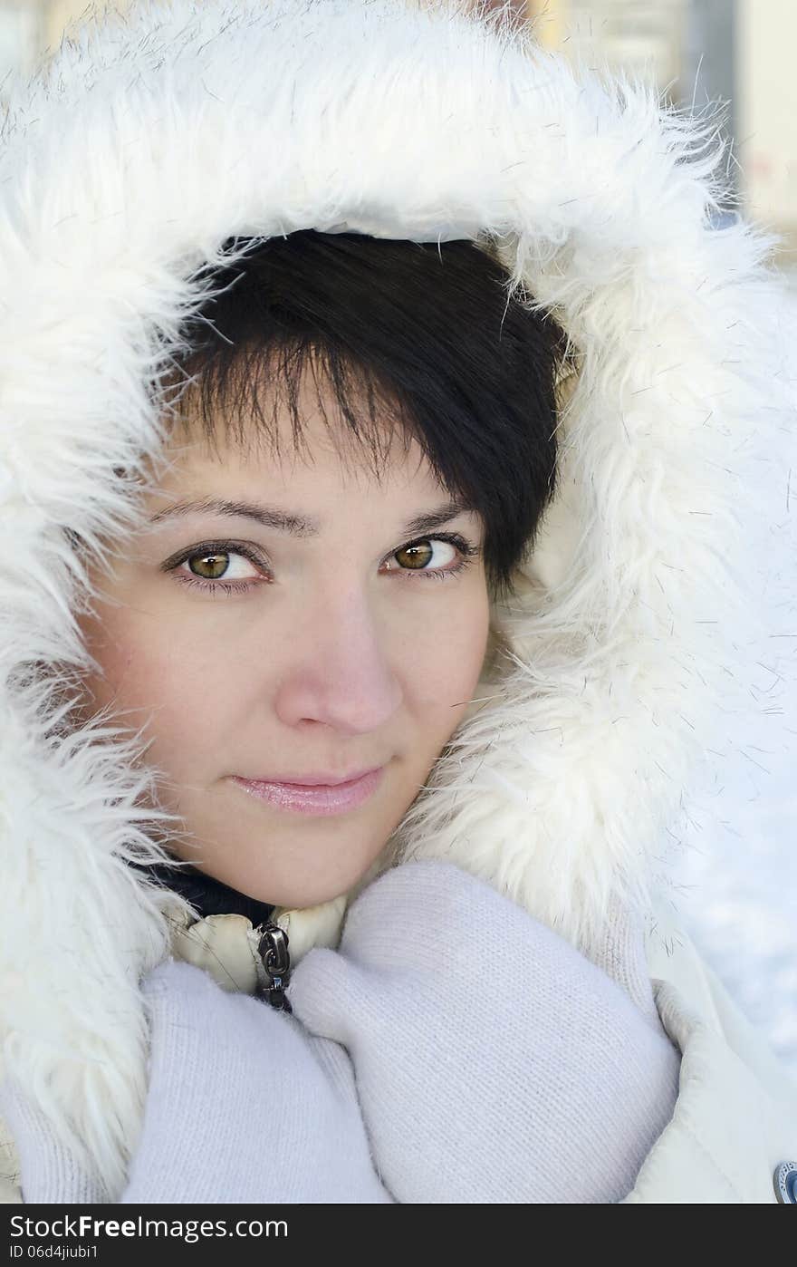 Beautiful winter portrait of young woman in the winter snowy