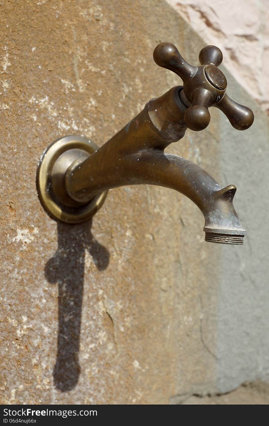 Old brass faucet on the wall