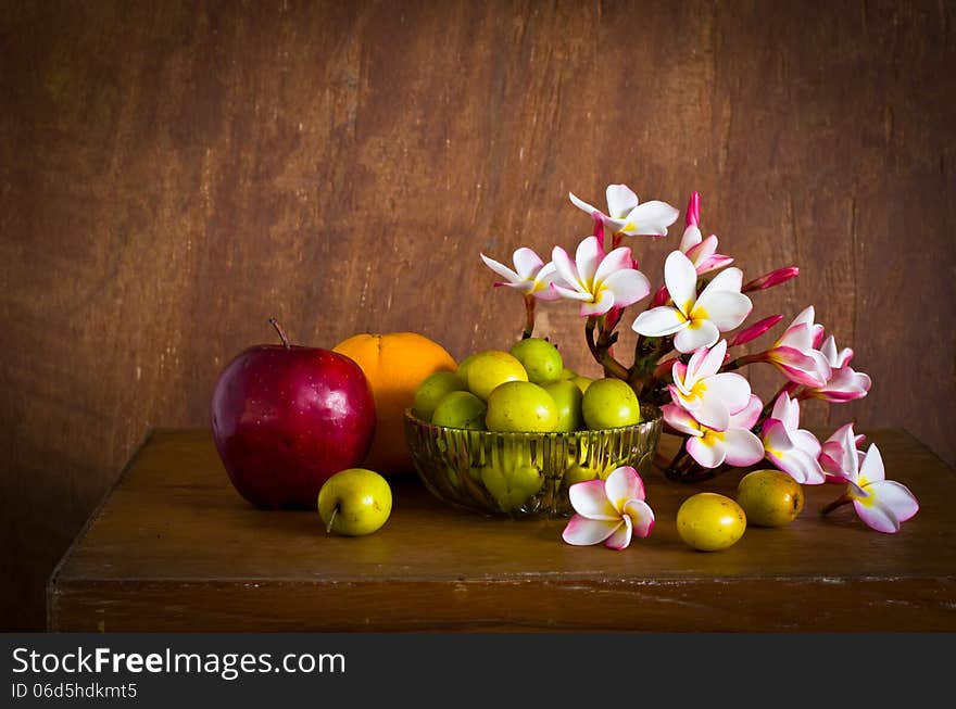 Plumeria flower and many fruit on old wood table