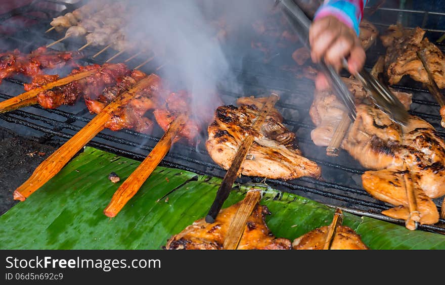 Market women flip the roast chicken