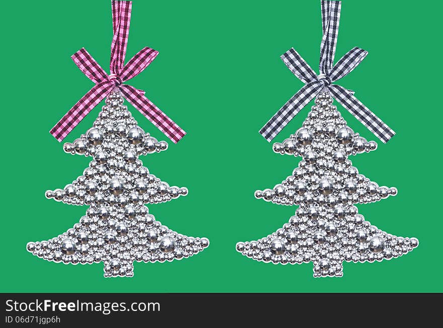 Two silver Christmas tree - decoration isolated on green background. Two silver Christmas tree - decoration isolated on green background