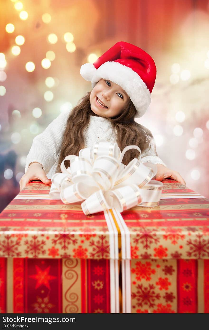 Child in Santa hat with gift box.