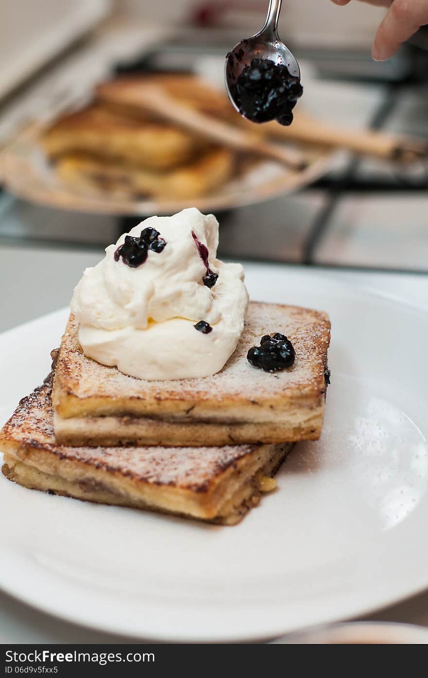 Decorating french toast with blueberry jam