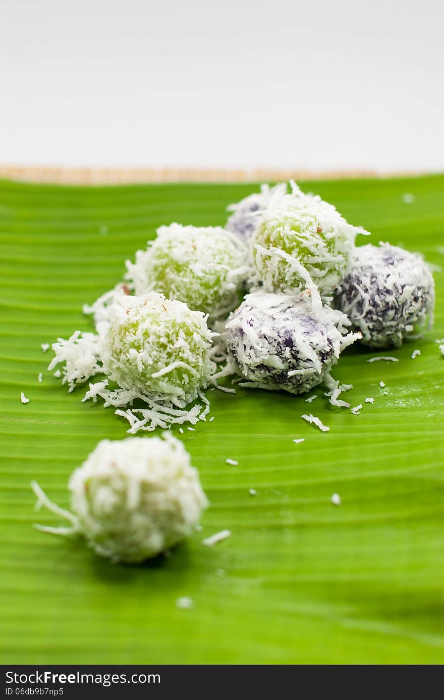 Thai dessert sweet boiled ball , roll over the grated coconut on banana leaf