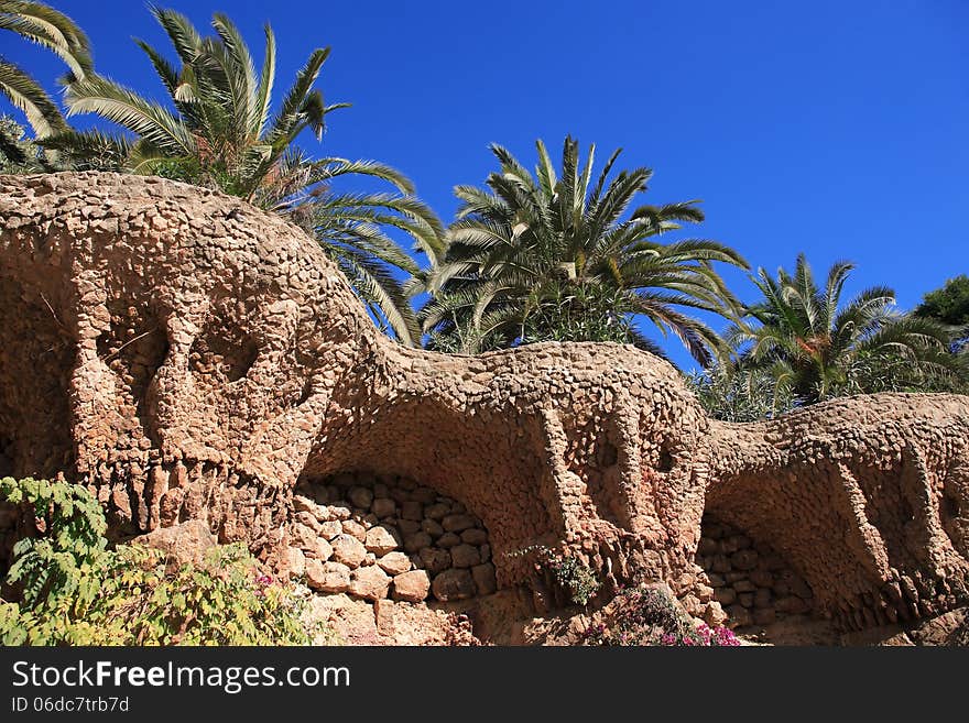 Palm trees on the nice wave wall in Park Guell. Barcelona, Spain