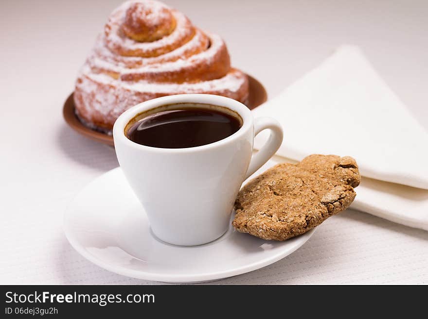 Cup of Black Coffee on White Plate with a Sweet Bun and Rye Cookie. Cup of Black Coffee on White Plate with a Sweet Bun and Rye Cookie