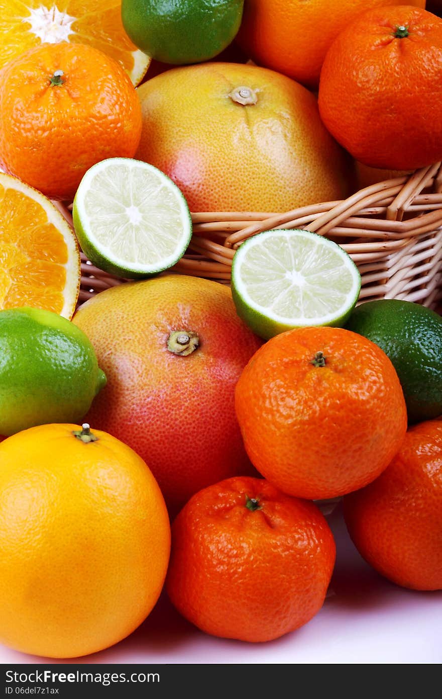 Wicker basket with various types of citrus fruits on white background. Wicker basket with various types of citrus fruits on white background