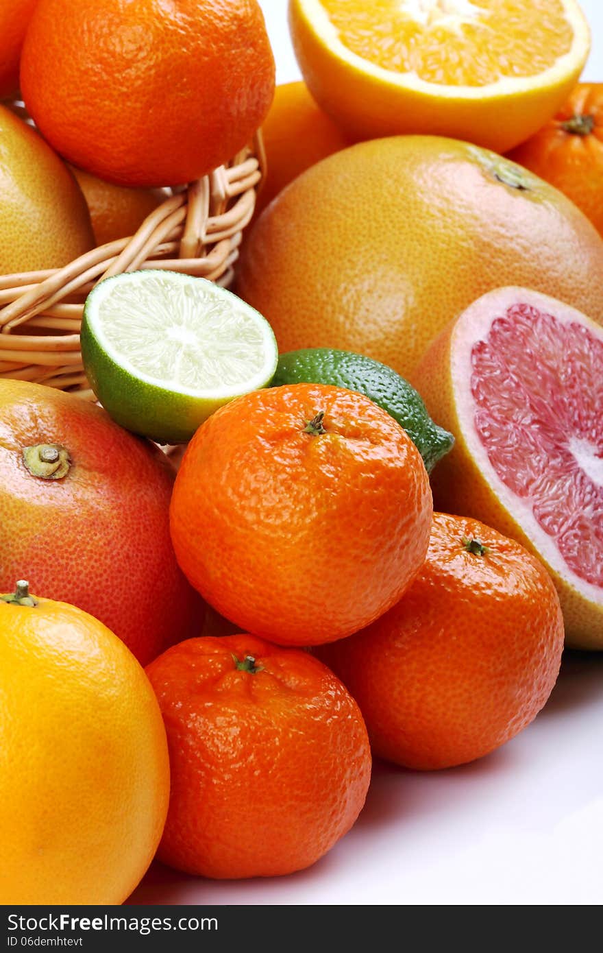 Wicker basket with various types of citrus fruits on white background. Wicker basket with various types of citrus fruits on white background