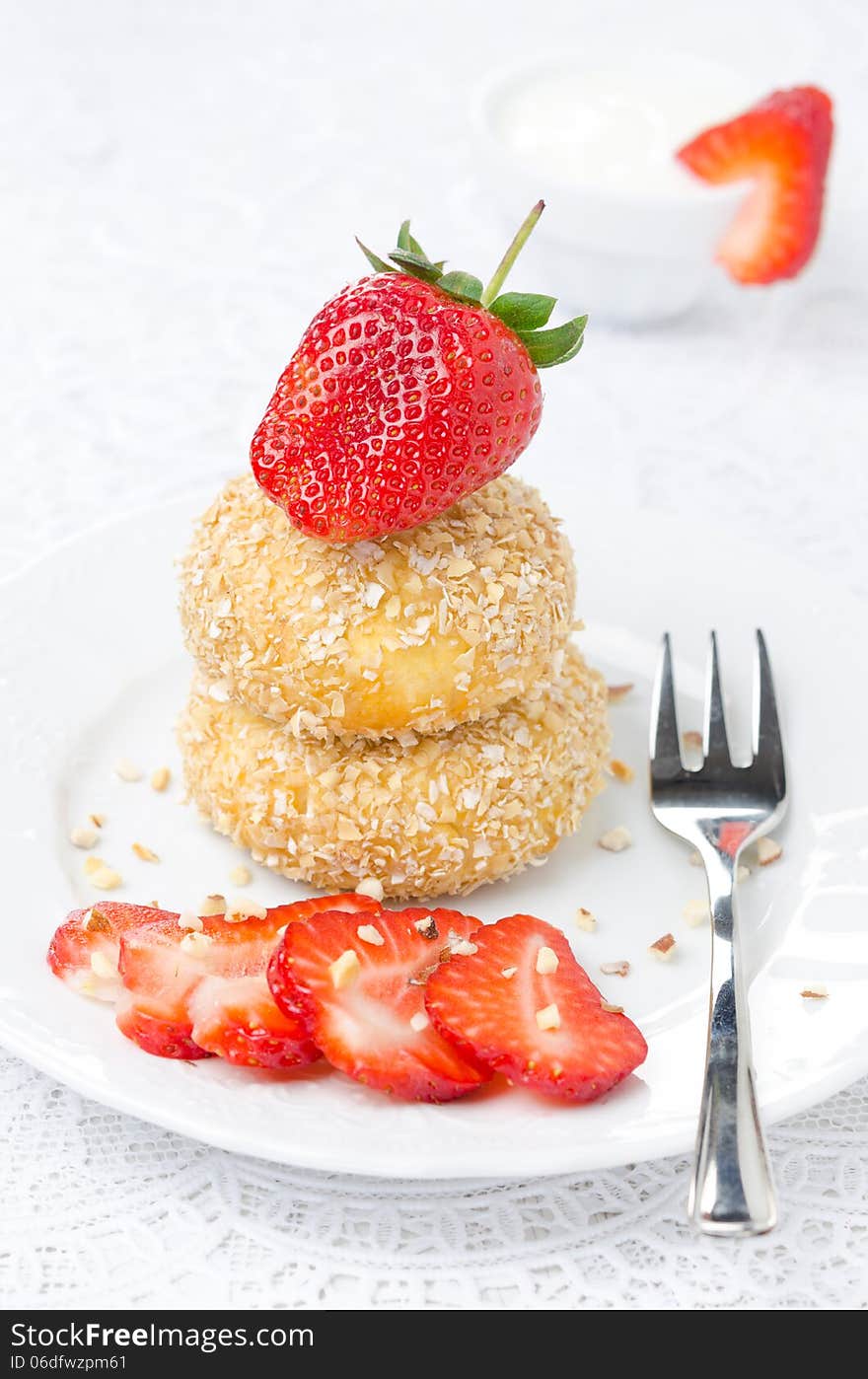 Cheese pancakes with fresh strawberries on a plate and yogurt