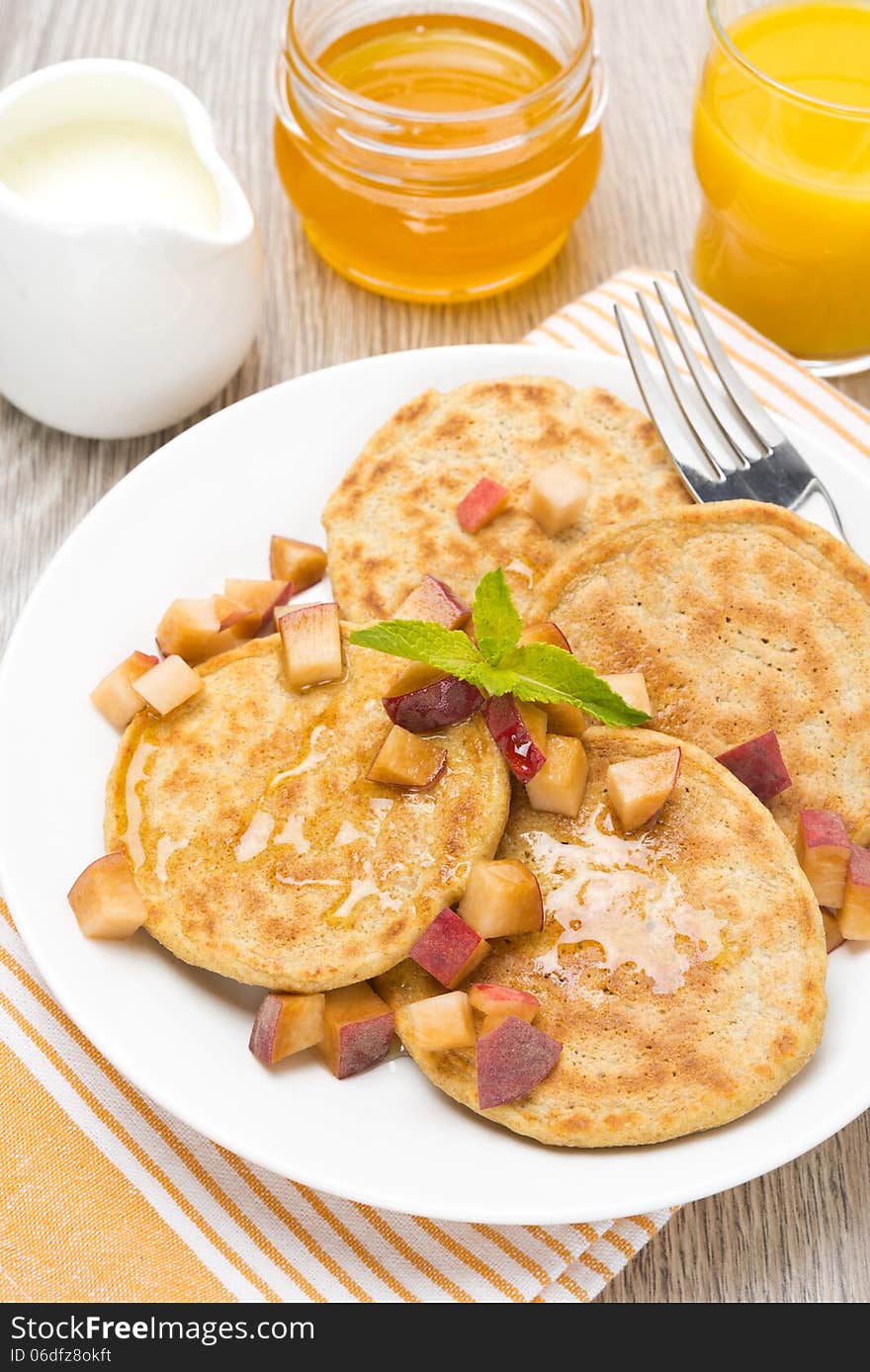 Pancakes with peaches and honey for breakfast, top view