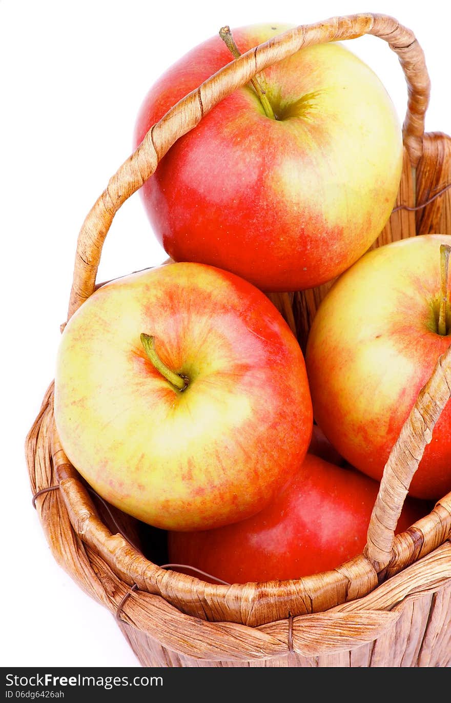 Delicious Ripe Red and Yellow Apples in Wicker Basket closeup on white background. Delicious Ripe Red and Yellow Apples in Wicker Basket closeup on white background