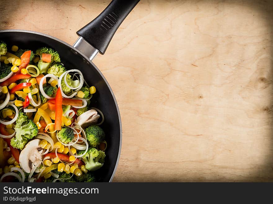 Frying Vegetables In Pan On Wood Background