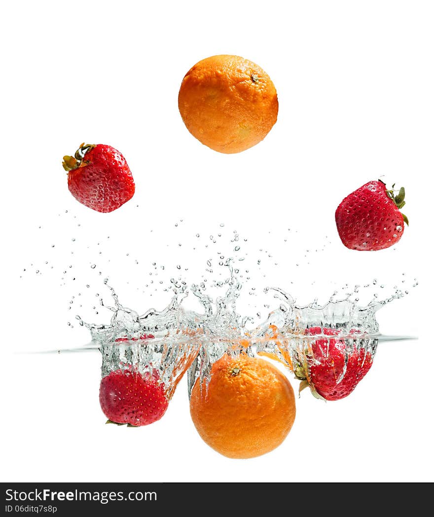 Orange and strawberries falling into the water. Orange and strawberries falling into the water