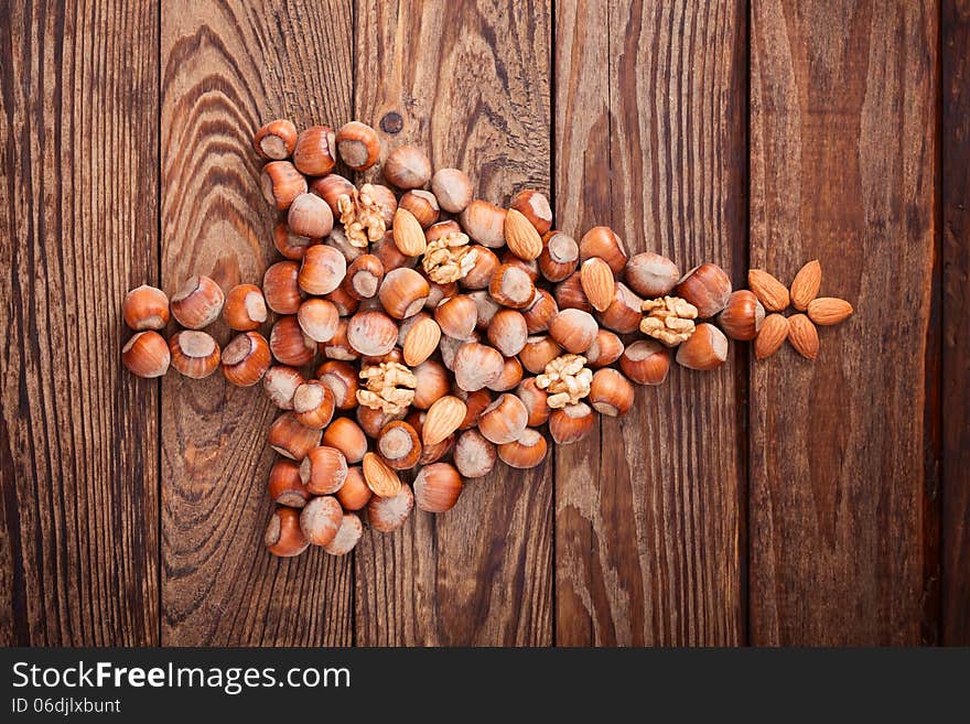 Hazelnuts, filbert on old wooden background. Christmas tree made of hazelnuts on a wooden surface