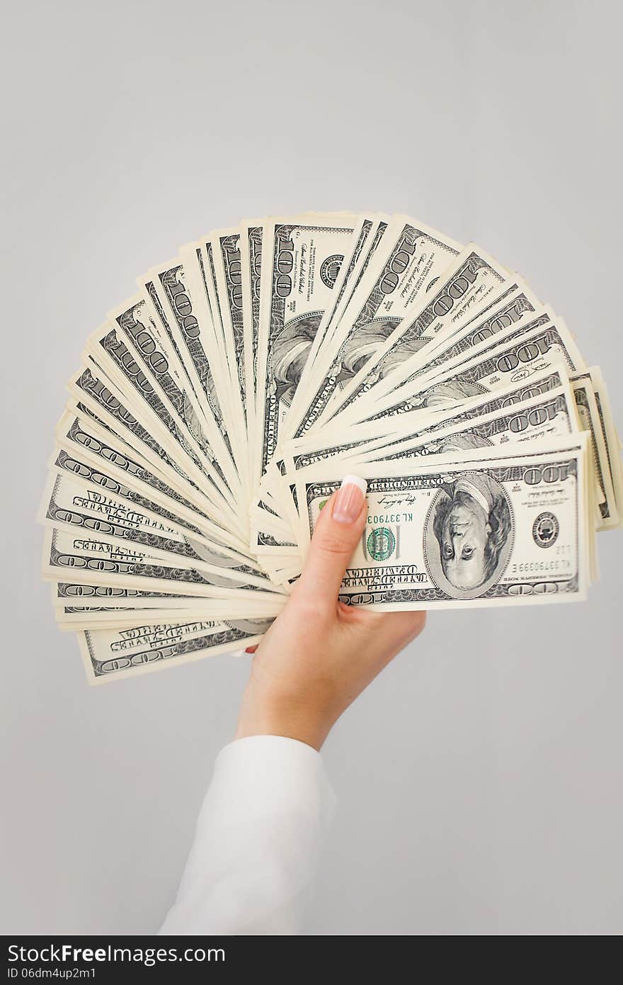 A young woman with dollars in her hands, isolated on white