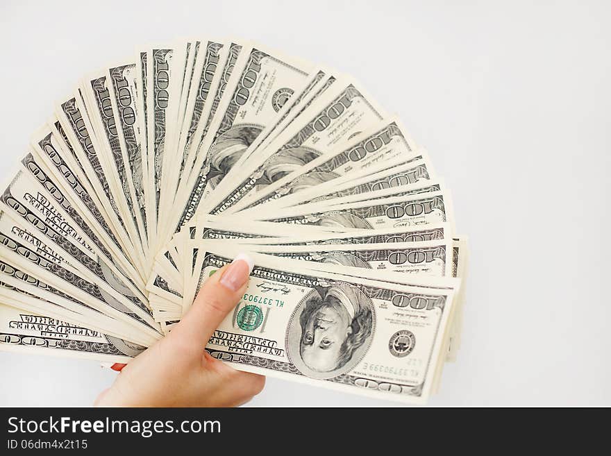 A young woman with dollars in her hands, isolated on white