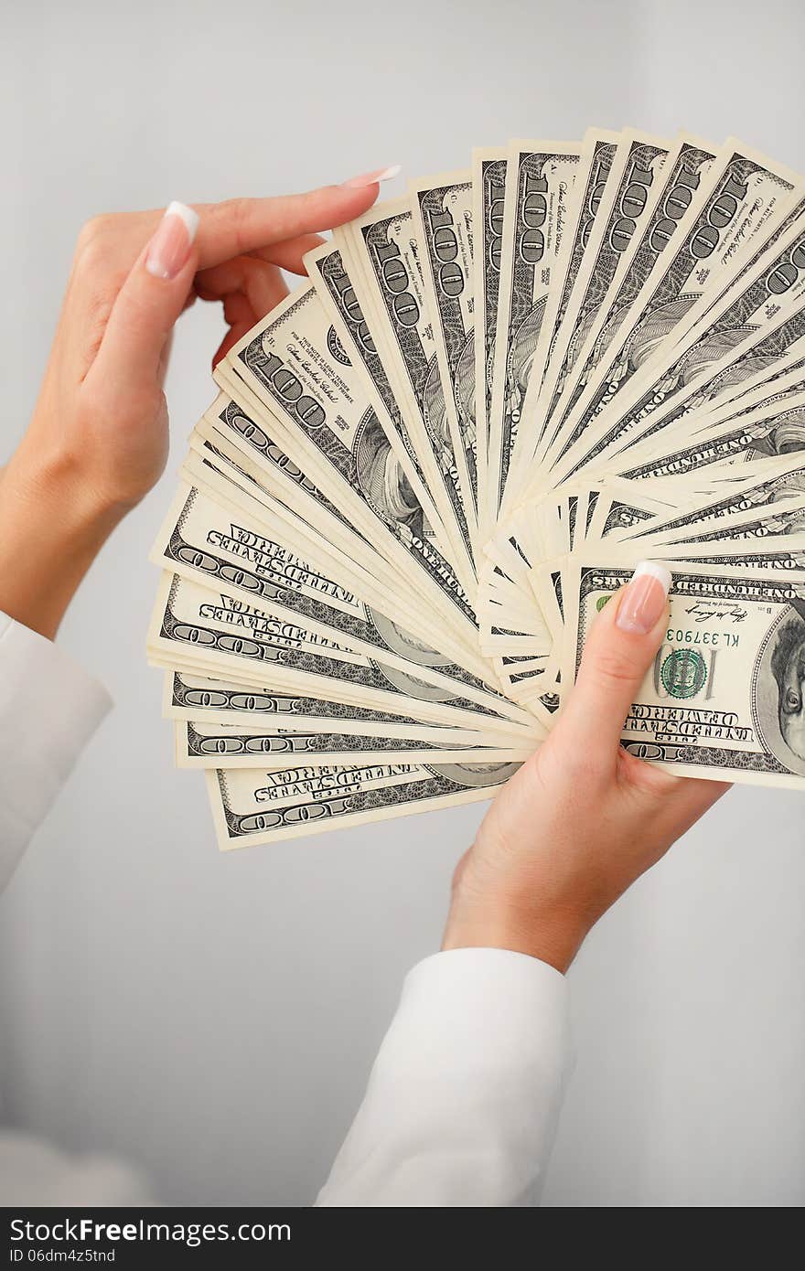 A young woman with dollars in her hands, isolated on white