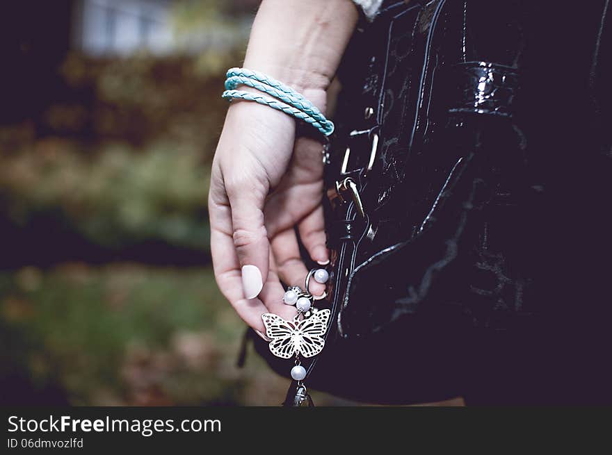 Young woman with silver jewelry on hand with black bag. Young woman with silver jewelry on hand with black bag