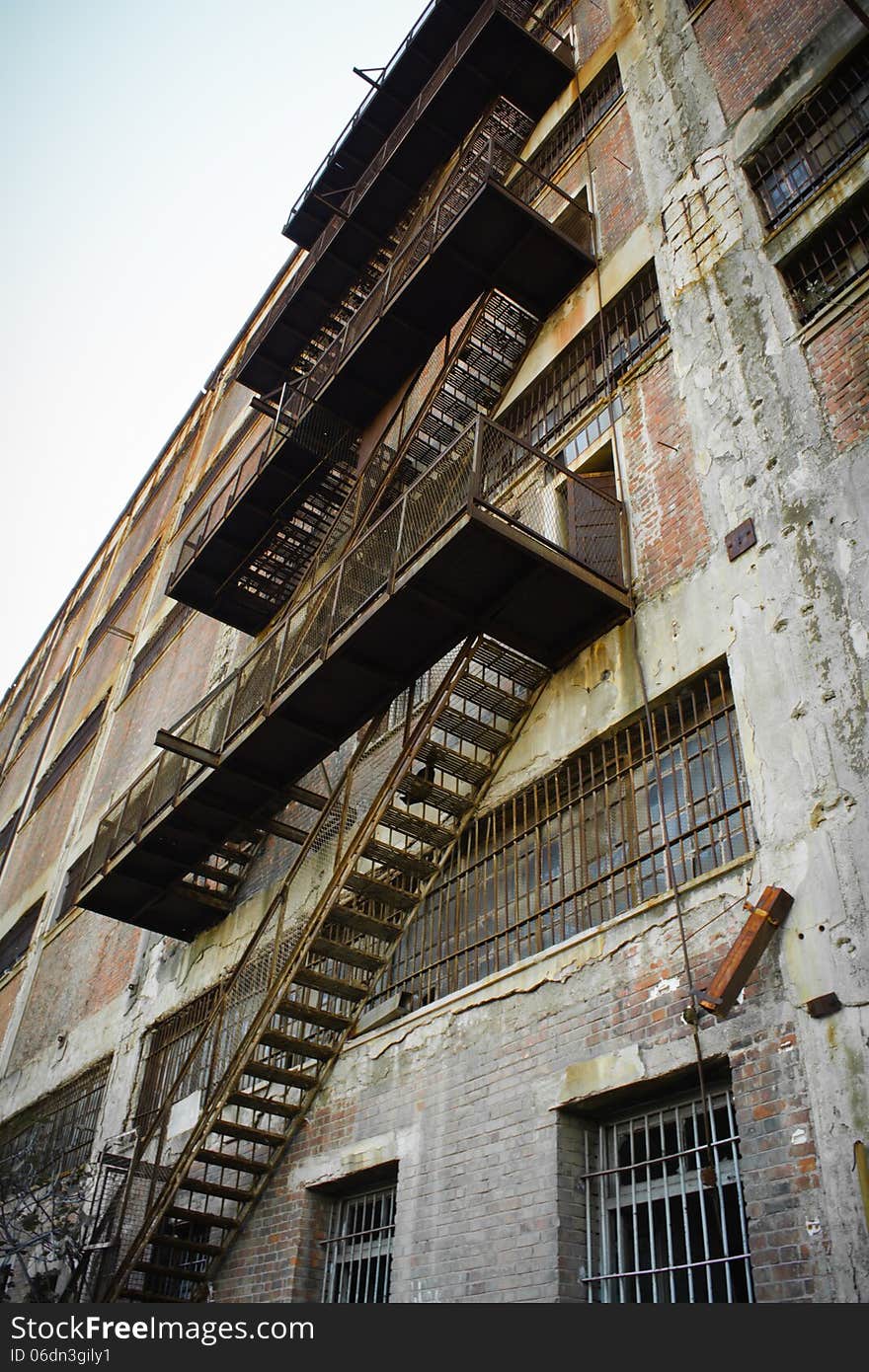 Rusty Old Fire Escape Stairs on Warehouse Brick Wall.