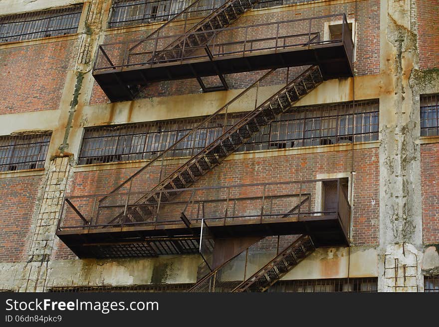 Rusty Old Fire Escape Stairs on Warehouse Brick Wall.