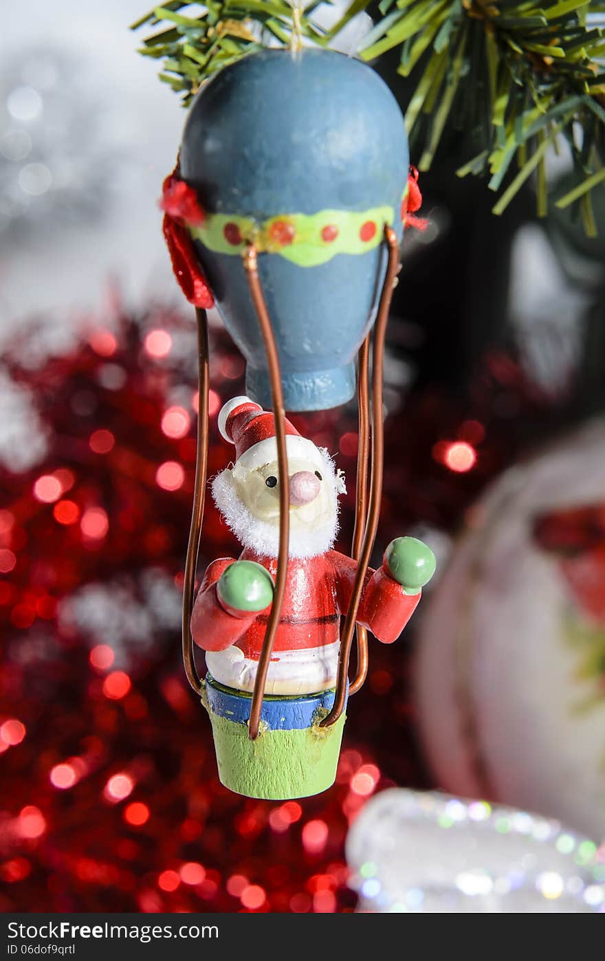 Small Santa Claus Christmas decoration fly under the tree to bring gifts.