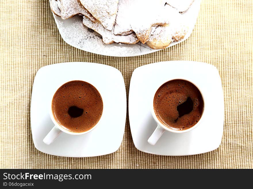 Two cups of coffe with cookies