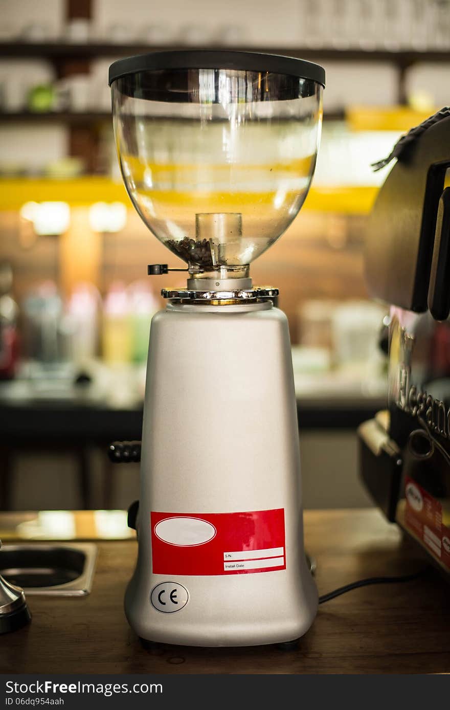 Coffee grinder on a wooden table in a coffee shop.