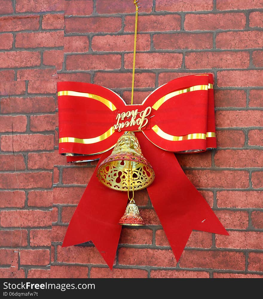 a golden christmas bell with red ribbon